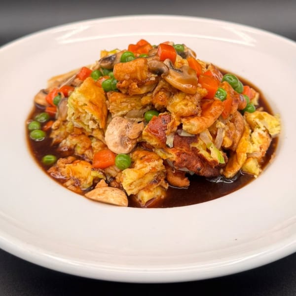Peking Restaurant's egg foo young with mushrooms, peas, and carrots in a rich brown sauce.