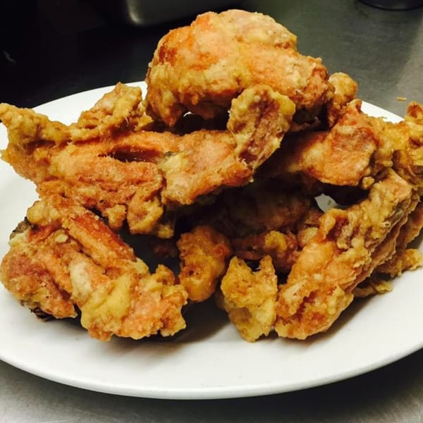 A white plate piled high with crispy, golden-brown fried chicken pieces from Peking Restaurant.