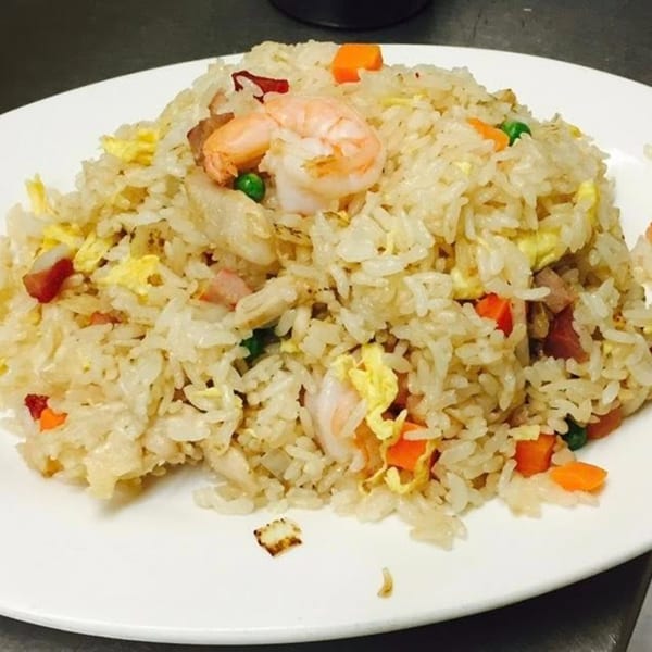 Peking Restaurant's shrimp fried rice with peas, carrots, and scrambled egg on a white plate.