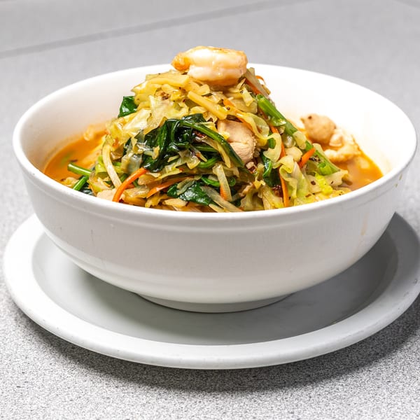 Peking Restaurant's Chinese soup with shrimp, chicken, cabbage, spinach, and carrots in a white bowl.