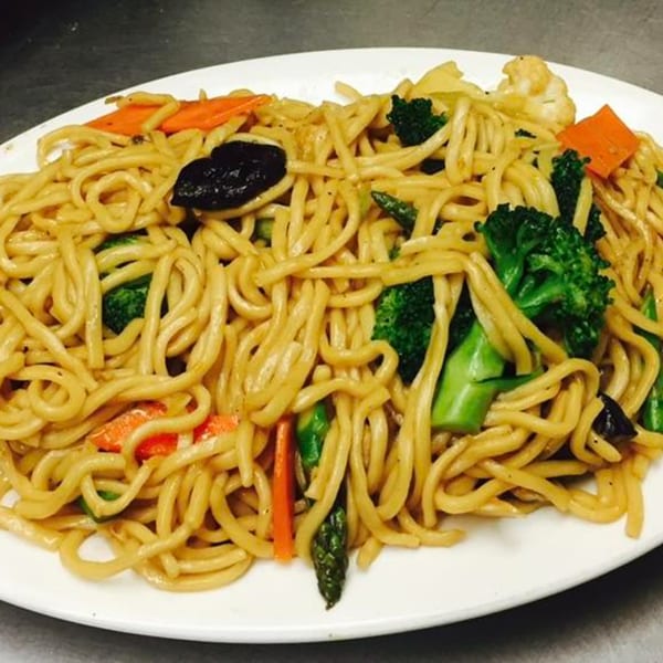 Peking Restaurant's vegetable lo mein with noodles, broccoli, carrots, and mushrooms on a white plate.